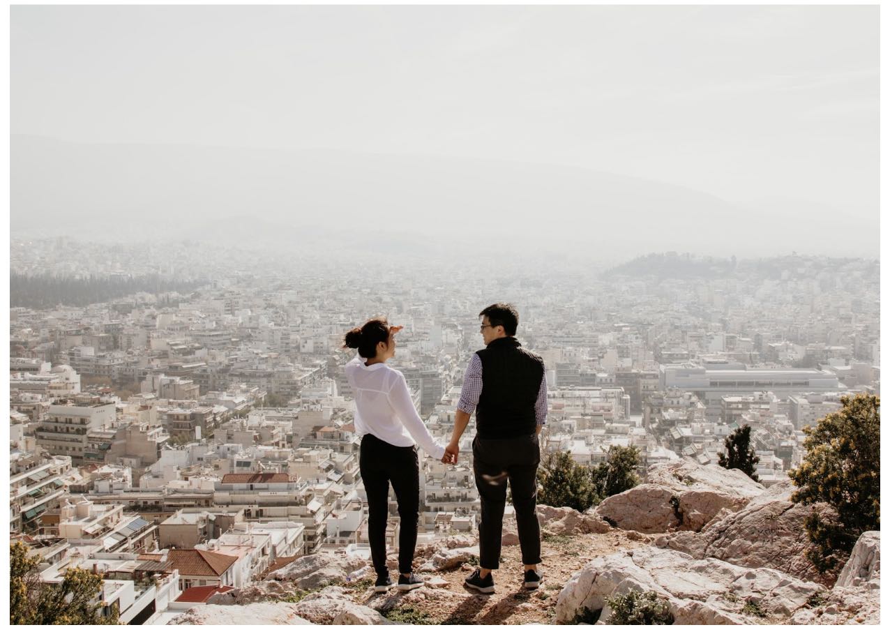 Happy Couple Holding Hands on Mountain Overlooking View